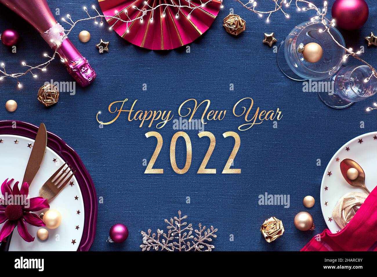 Felice anno nuovo 2021 testo dorato in cornice con tavolo festa di Capodanno. Decorazioni dorate, rosa e rosse su tessuti di lino. Foto Stock