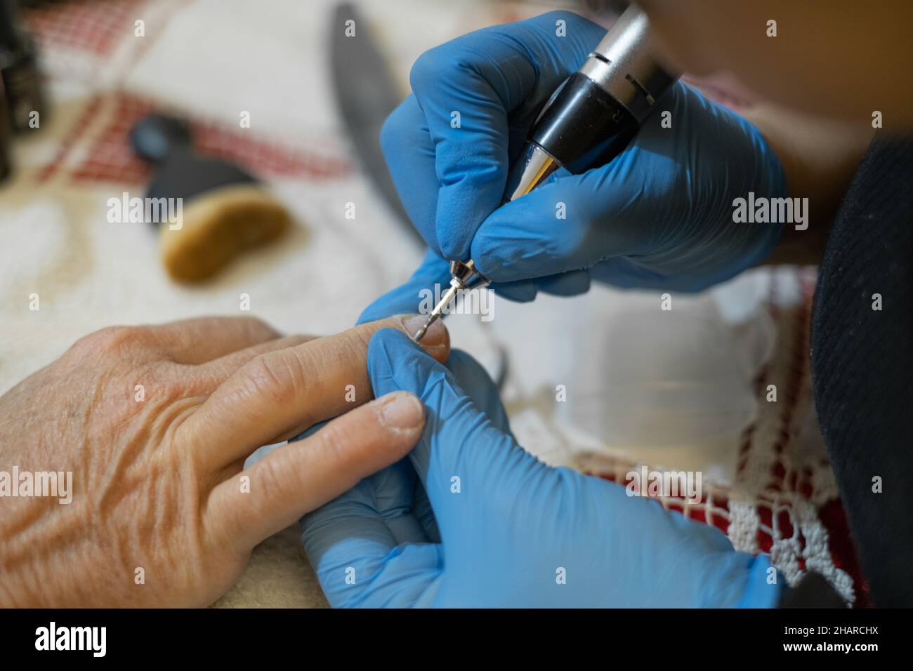 Estetista professionista mentre fa onicomicosi trattamento e ricostruzione del chiodo ad un cliente, terapia di salute Foto Stock