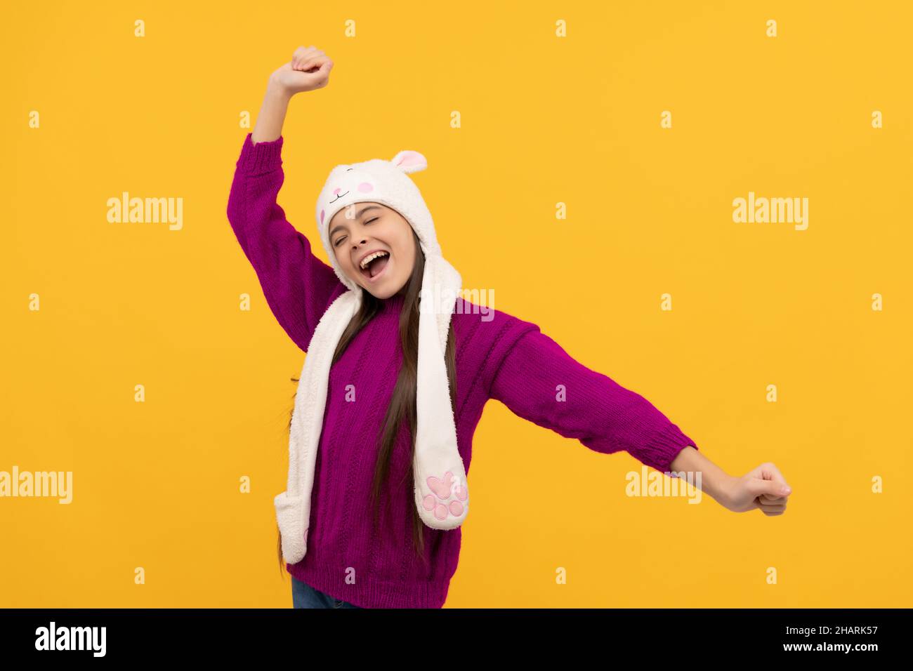 i bambini indossano abiti caldi su sfondo giallo, moda e bellezza invernali. Foto Stock