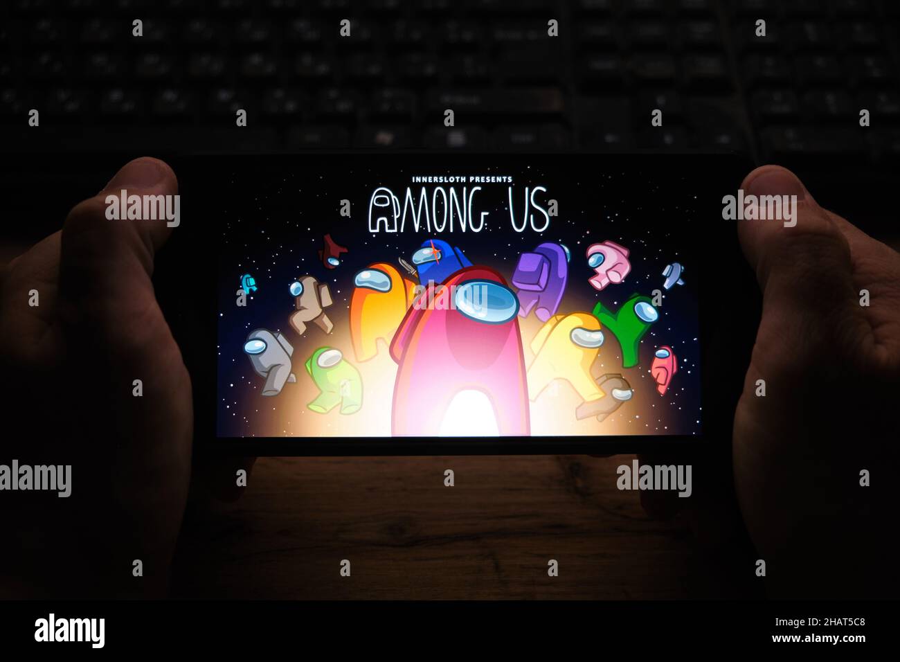 Kostanay, Kazakhstan, 04 novembre 2021.Un uomo possiede un telefono cellulare con uno screensaver del popolare gioco TAmong us Foto Stock