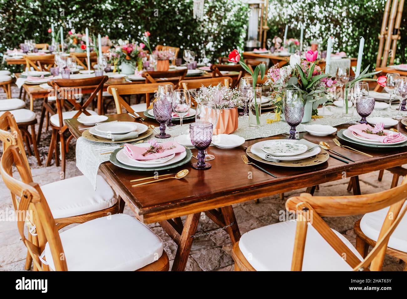 Terrazza con tavoli con fiori e piatti sul tavolo decorati per il ricevimento di nozze in America Latina Foto Stock