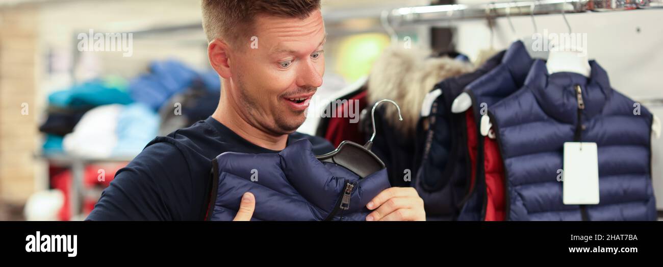 L'uomo prova sul gilet caldo nel primo piano del deposito Foto Stock