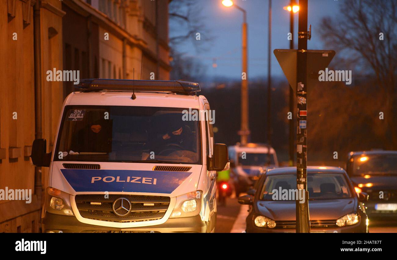 Dresda, Germania. 15th Dic 2021. Una macchina di polizia si trova sul marciapiede durante un raid nel distretto di Pieschen. Dopo le minacce contro il primo ministro della Sassonia Kretschmer su Telegram, la polizia di Dresda ha cercato diverse proprietà. Sono state coinvolte anche forze speciali dell'Ufficio di polizia penale di Stato (LKA), come hanno affermato i singoli membri del gruppo Telegram che potrebbero essere in possesso di armi taglienti e balestre, la polizia ha annunciato su Twitter. Credit: Robert Michael/dpa-Zentralbild/dpa/Alamy Live News Foto Stock