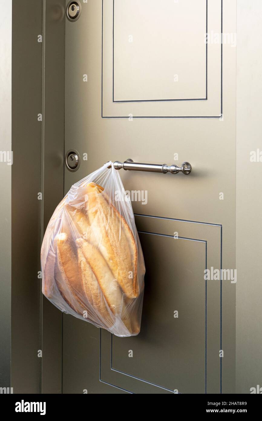 Primo piano di una borsa con pane bianco fresco. Consegna di pane e cibo durante le giornate pandemiche Foto Stock