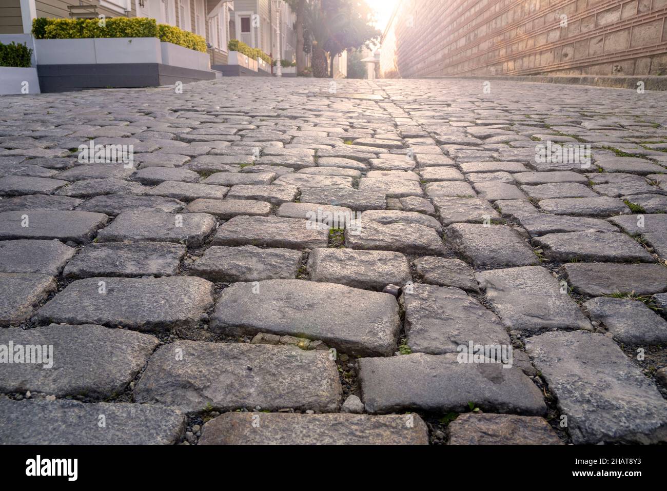 Strada lastricata vuota e la luce del sole al mattino Foto Stock