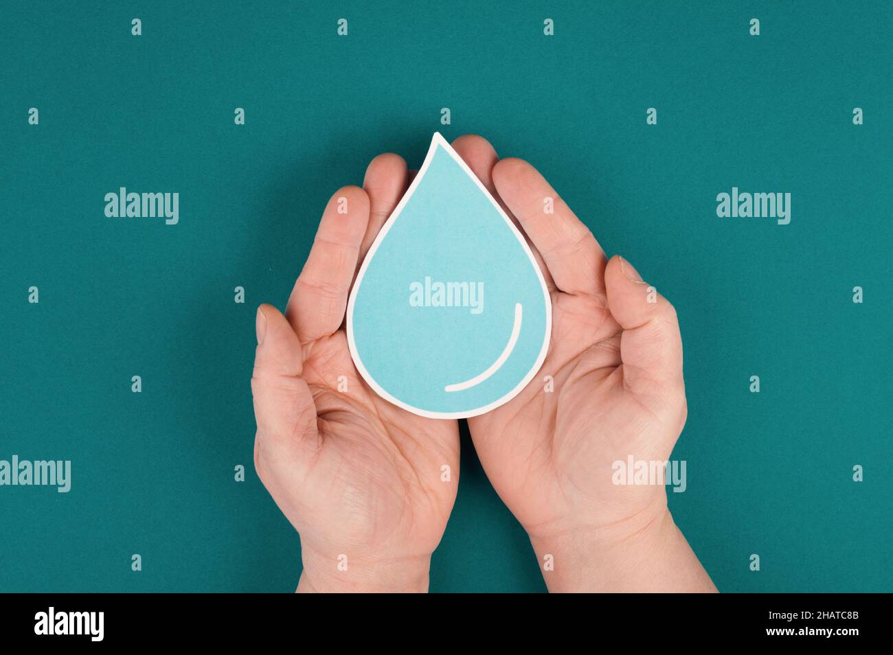 Mani che tengono una goccia d'acqua, carta tagliata, problema ambientale, spazio di copia per il testo Foto Stock