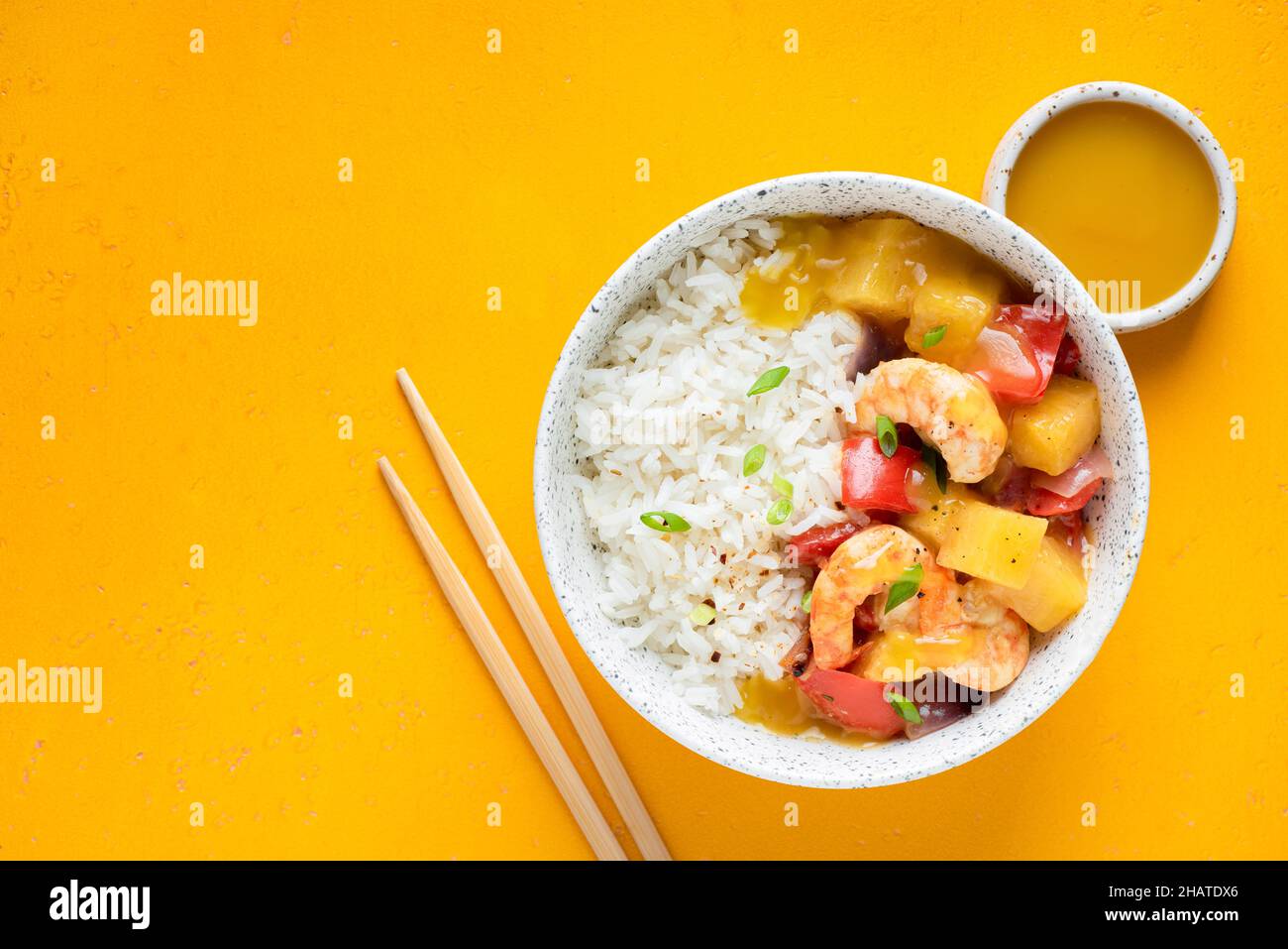 Gamberi di ananas riso in una ciotola, cucina asiatica. Sfondo giallo, vista dall'alto Foto Stock