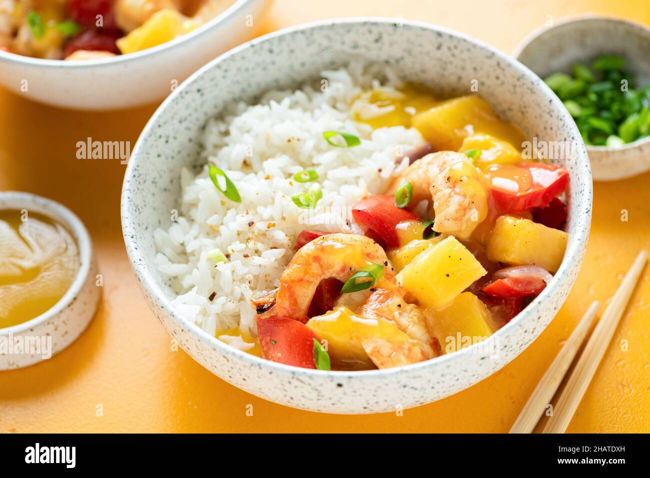 Riso con gamberi al curry di ananas in una ciotola, vista sul primo piano, sfondo giallo Foto Stock