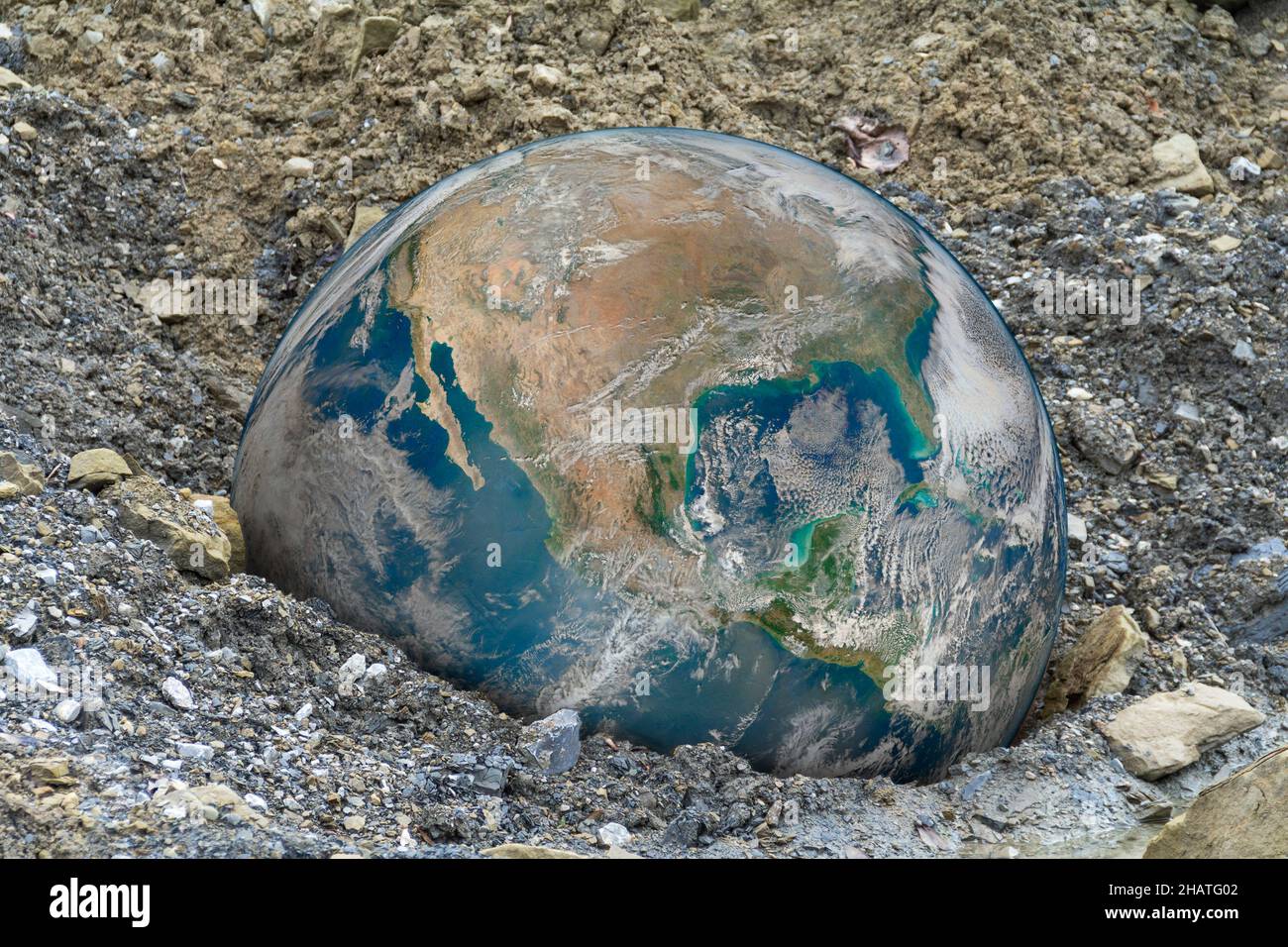 Simbolico globo terrestre caduto in ghiaia indietro Foto Stock