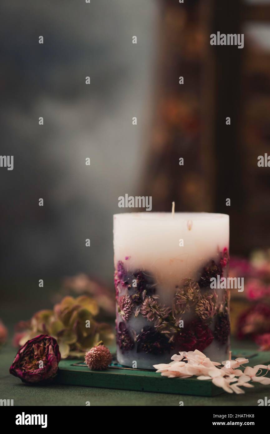 Candele fatte a mano con fiori secchi design unico. Candele profumate decorate con foglie secche e fiori. Messa a fuoco selettiva Foto Stock