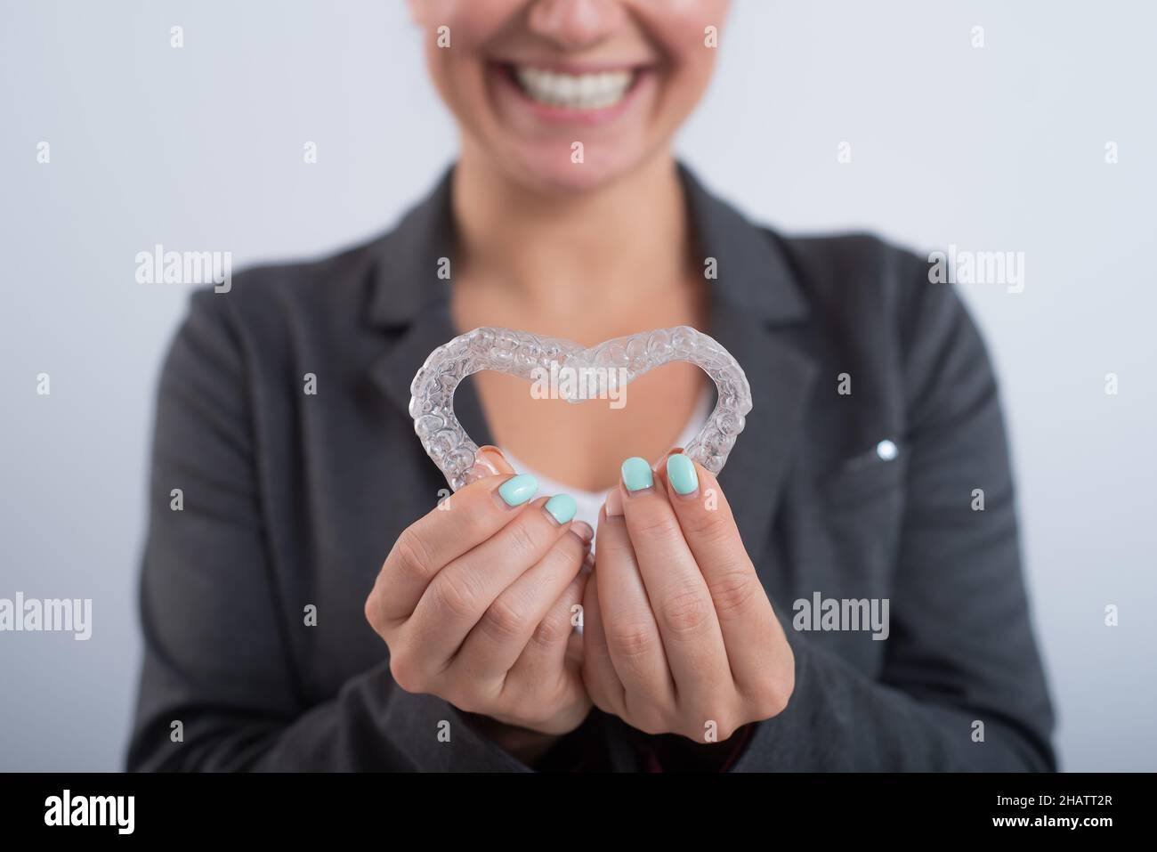 Donna caucasica con due allineatori trasparenti a forma di cuore Foto Stock