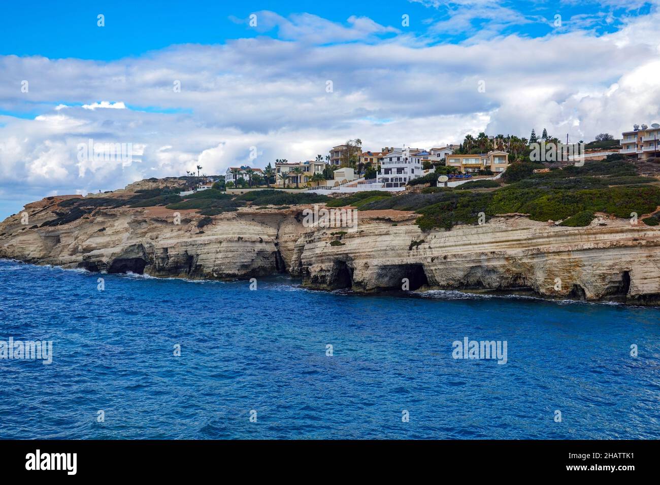 Le grotte marine ospitano le foche del Mistico e ville sulla scogliera, vicino a Coral Bay, Paphos, Cipro Foto Stock