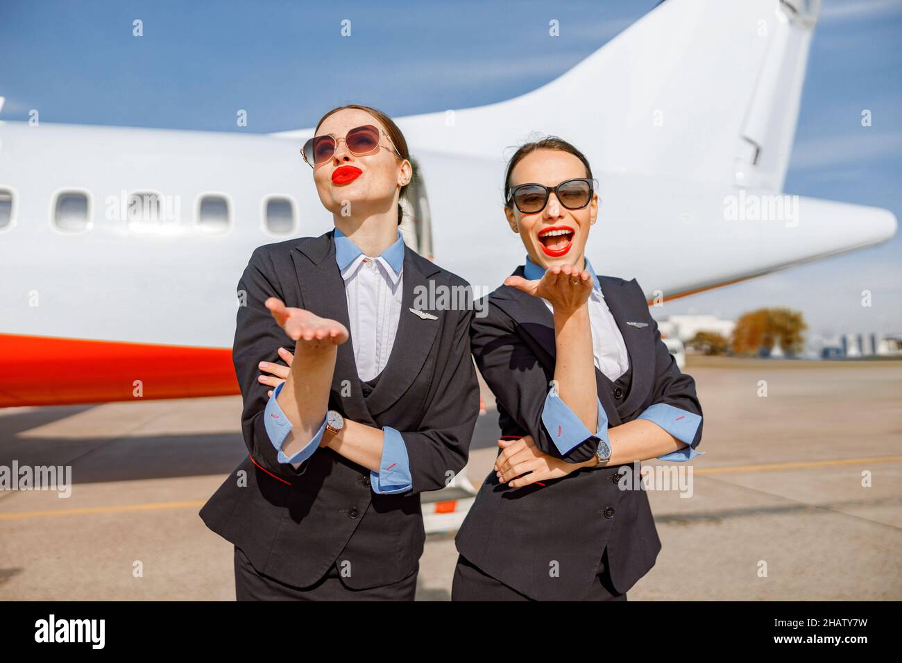 Donne allegre stewardesses inviare baci colpo all'aeroporto Foto Stock