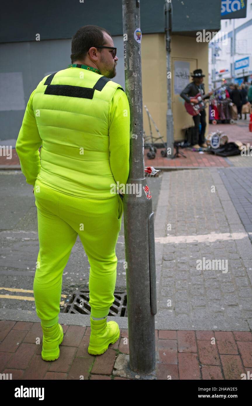 Un uomo in una tuta gialla attende su un angolo di strada Brighton Foto Stock