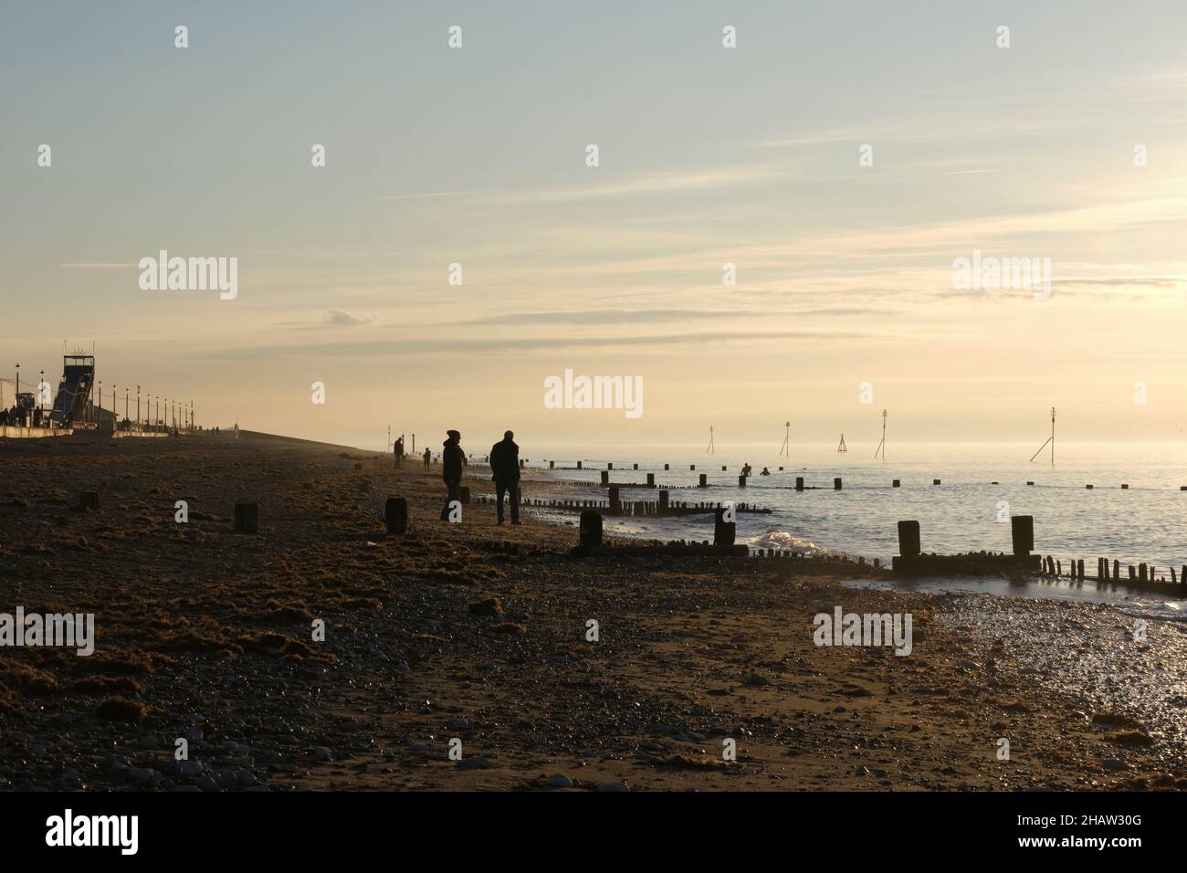 Le persone godono il tramonto invernale a piedi e nuoto sulla spiaggia di Hunstanton 2021 novembre Foto Stock