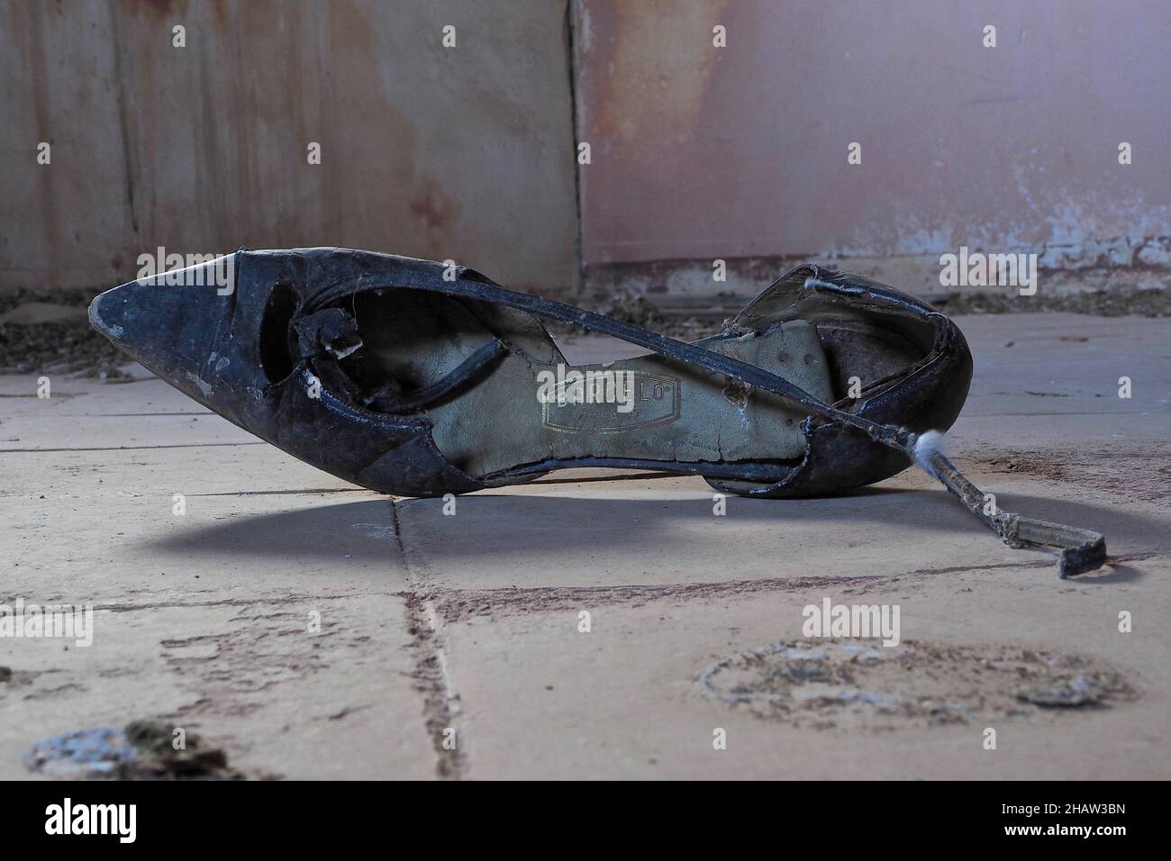 Nera vecchia scarpa da donna rotta giacente sul pavimento, trovare scarpe in una casa abbandonata, Andalusia, Spagna Foto Stock