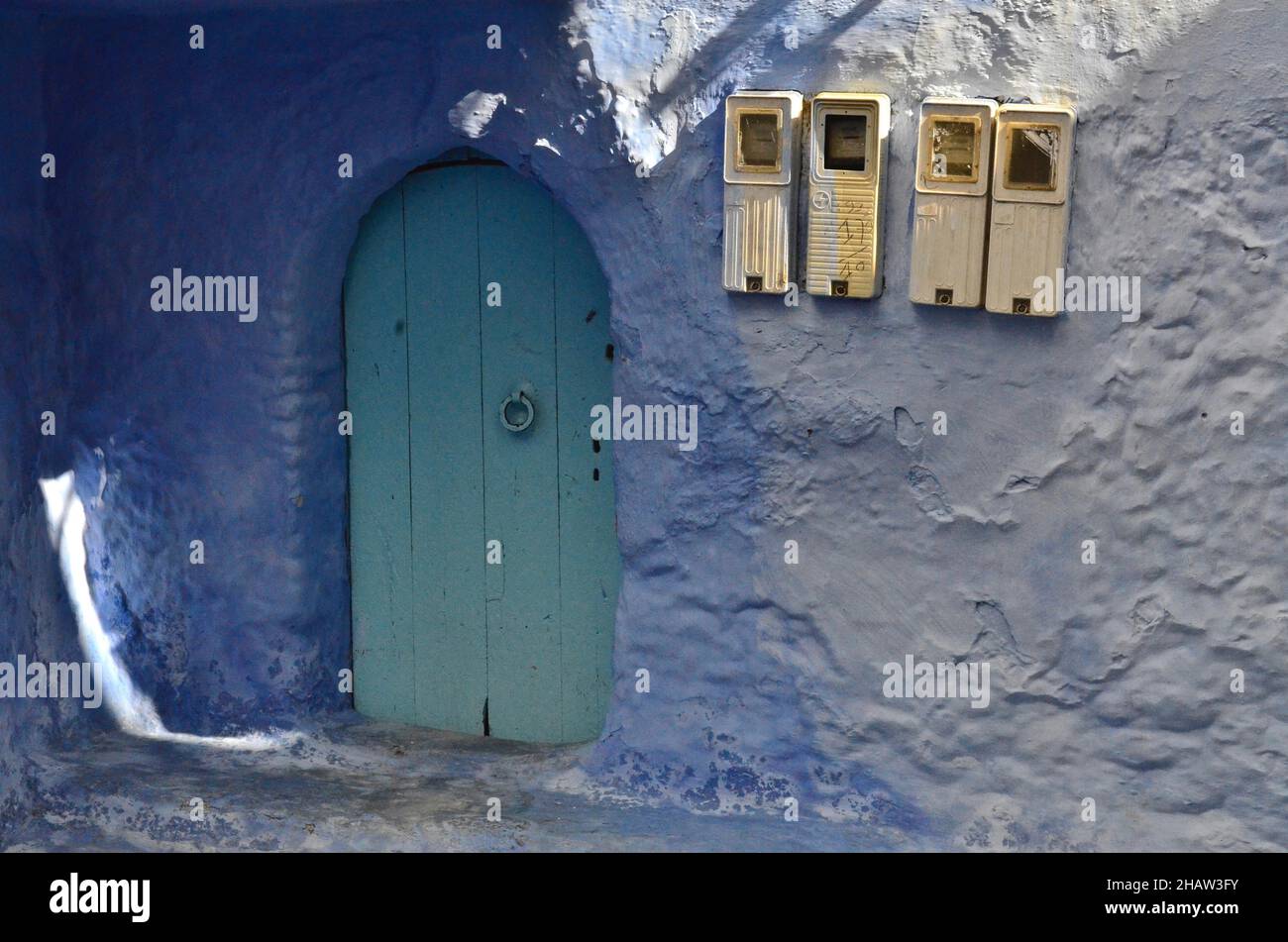 Casa con porta color menta con parete blu e quattro scatole fusibili, porta verde con anello di detonazione, città blu, Chefchaouen, Tangeri-Tetouan-al Foto Stock