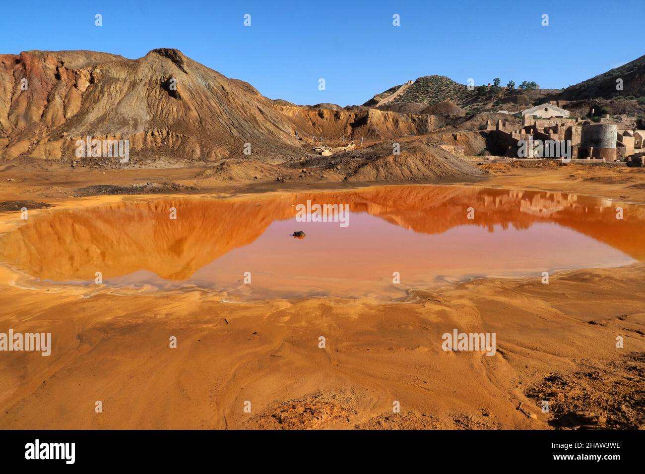 Montagna con pozzanghere rosse e costruzione di mine, Mazarron, Murcia, Spagna Foto Stock