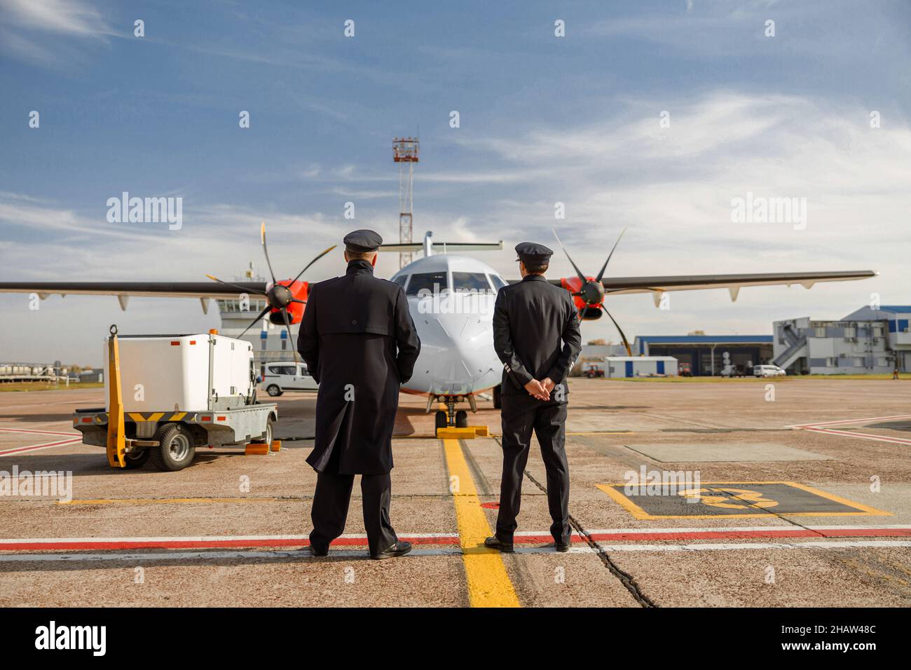 Lavoratori di linea maschile in piedi all'aperto in aeroporto Foto Stock