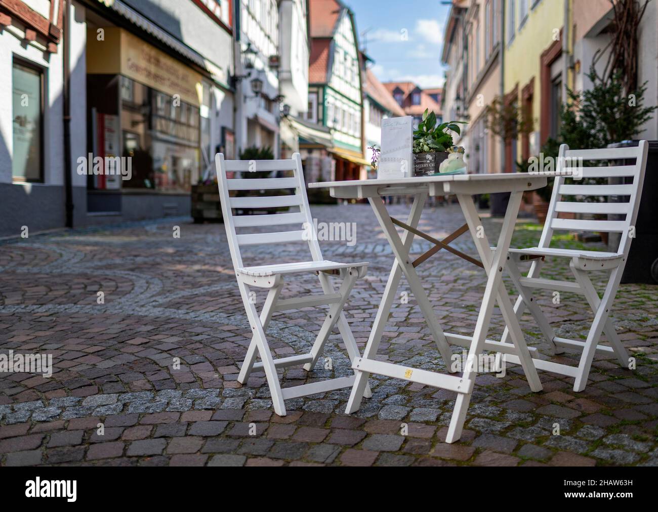 Tavolo e sedia in legno in un piccolo vicolo, Gelnhausen, Assia, Germania Foto Stock