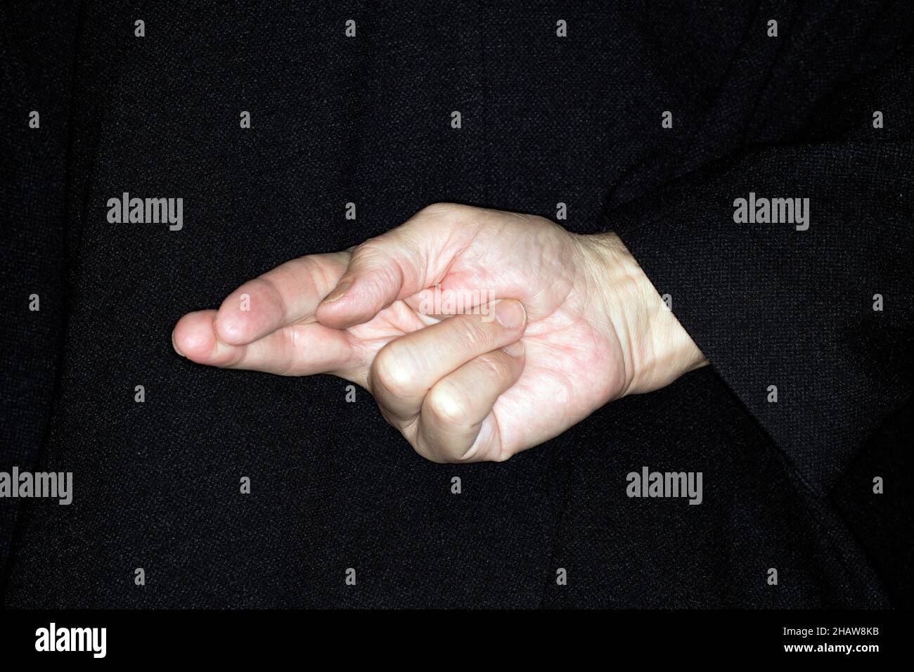 Dita incrociate dietro la schiena, gesto, promessa interrotta, fotografia in studio Foto Stock