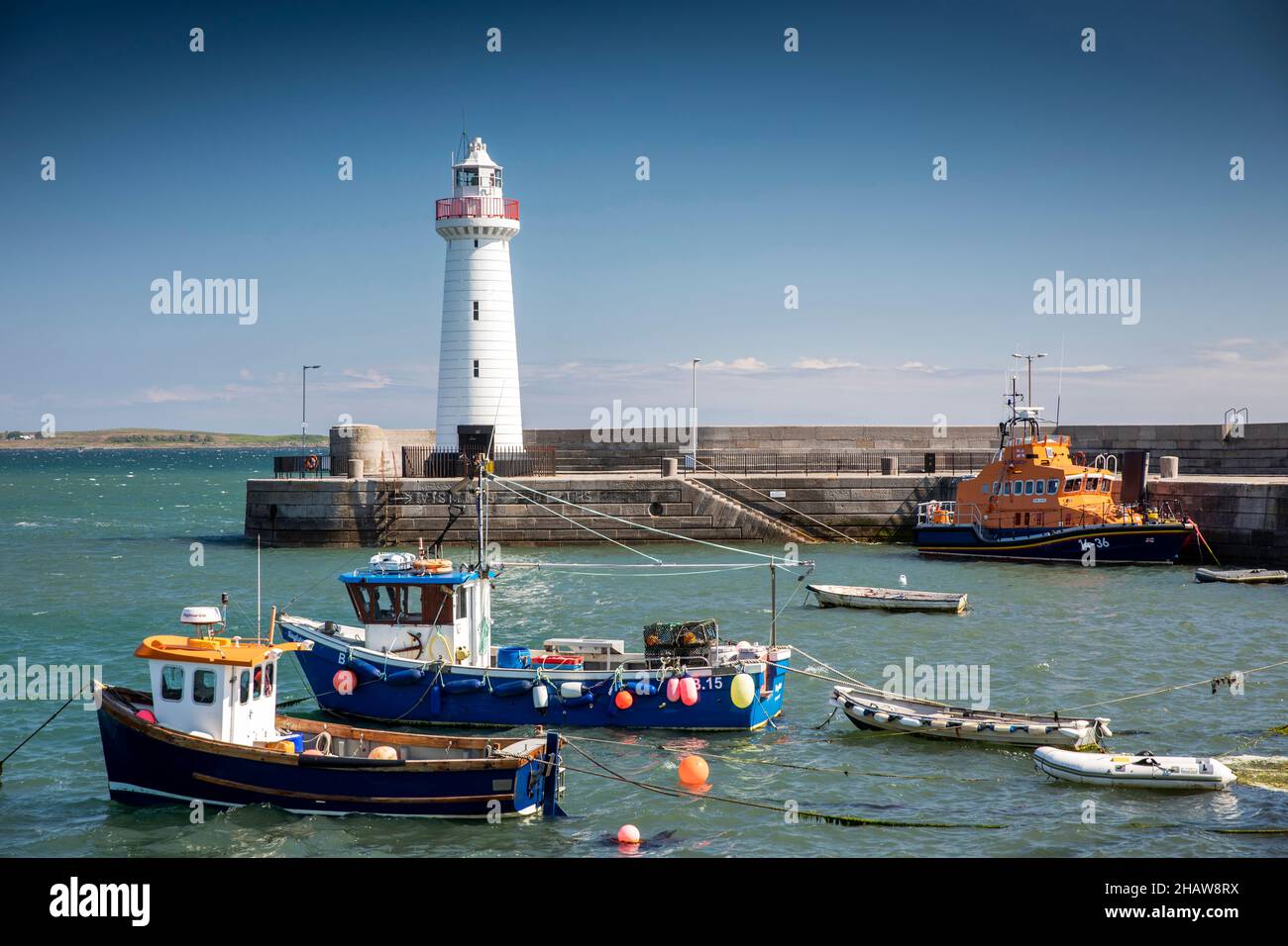 Regno Unito Irlanda del Nord, Co Down, Donaghadee, Porto, barche da pesca e RNLI Lifeboat ormeggiato vicino al faro Foto Stock