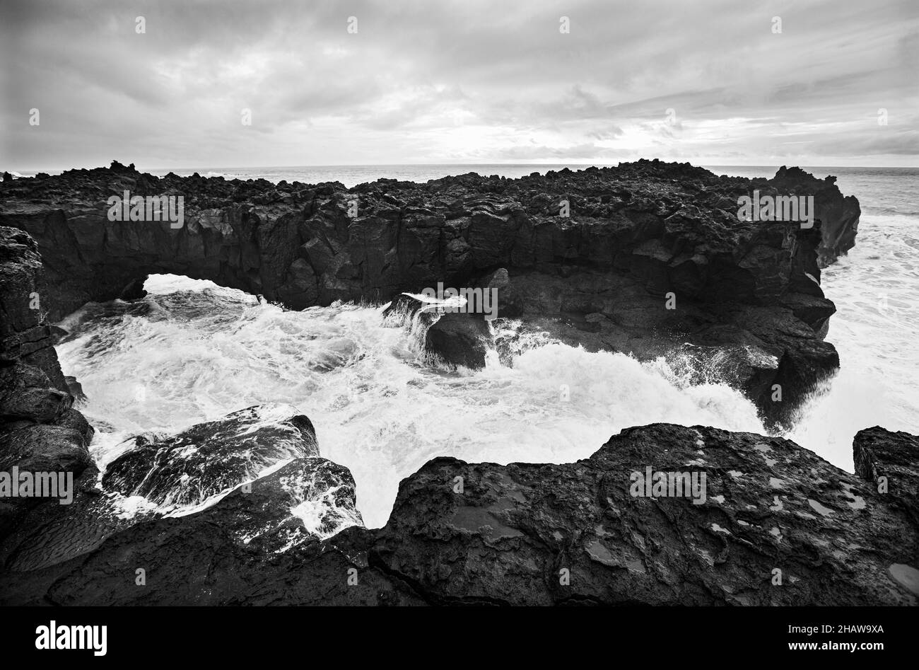 Arco di lava sulla costa vulcanica ad alta marea con onde alte, Ponta da Ferraria, Isola di Sao Miguel, Azzorre, Portogallo Foto Stock