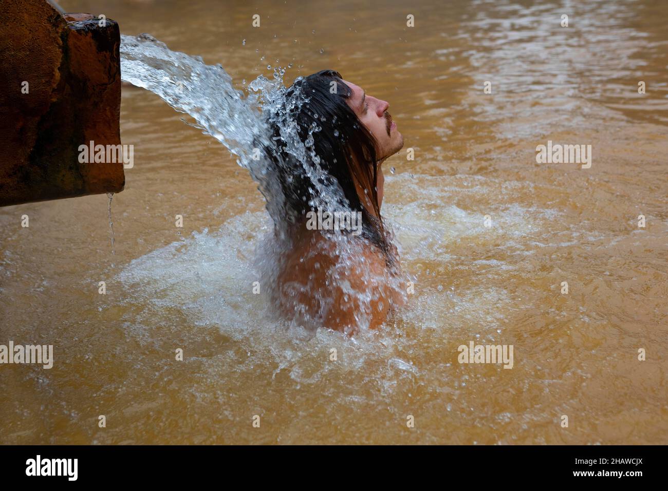 Giardino botanico, uomo sotto il getto d'acqua in piscina di acqua termale nel Parco Terra nostra, Furnas, Isola di Sao Miguel, Azzorre, Portogallo Foto Stock