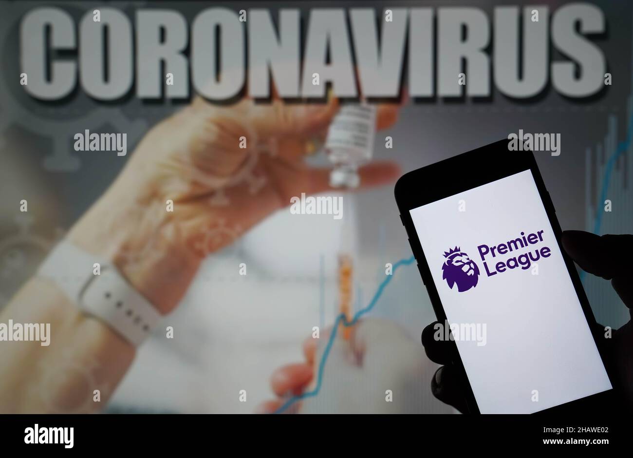 Foto del file datata 09-01-2021 del logo Premier League visualizzata su un telefono cellulare con un'illustrazione di Coronavirus su un monitor sullo sfondo. La Premier League ha respinto almeno una richiesta di rinvio di una partita a causa dei casi positivi di Covid-19 questa settimana, capisce l'agenzia di stampa PA. Data di emissione: Mercoledì 15 dicembre 2021. Foto Stock