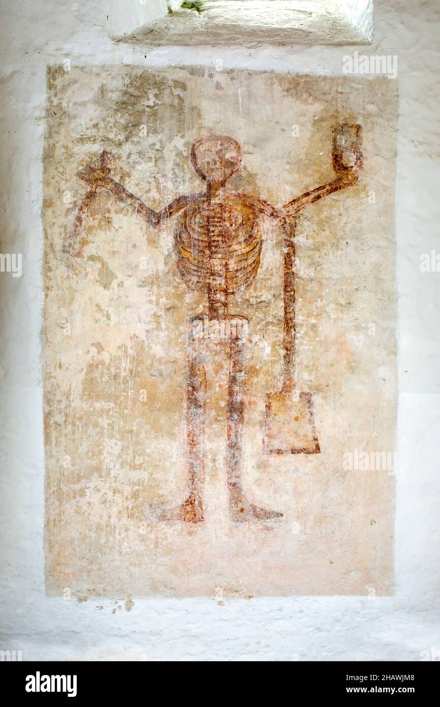 Dipinto di uno scheletro raffigurante il tempo, che porta una falce, una vanga e una clessidra, sulla parete interna della Chiesa di Sant'Issui, Partrishow, Powys, Galles Foto Stock