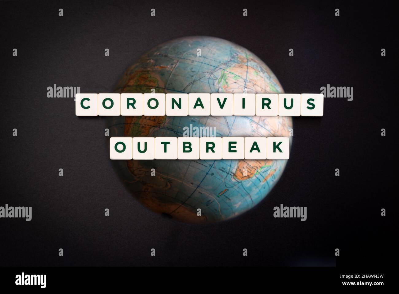 Segnale di epidemia di coronavirus, composito digitale. Malattia infettiva pandemica mondiale. Problema globale. Testo su terra sfocata e sfondo scuro Foto Stock