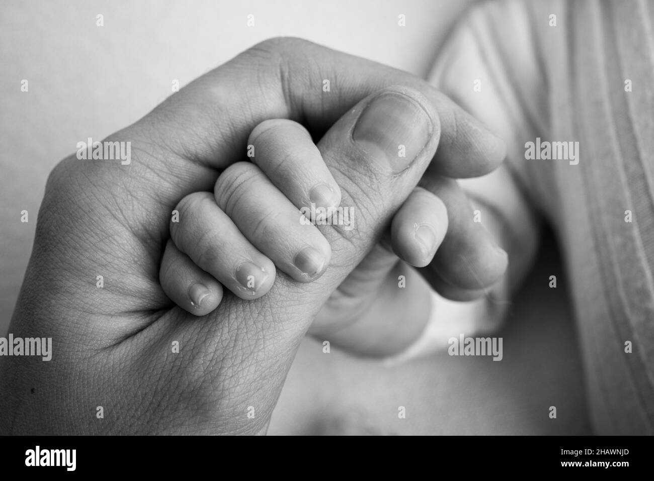 Il neonato ha una presa salda sul dito del genitore dopo la nascita. Foto Stock