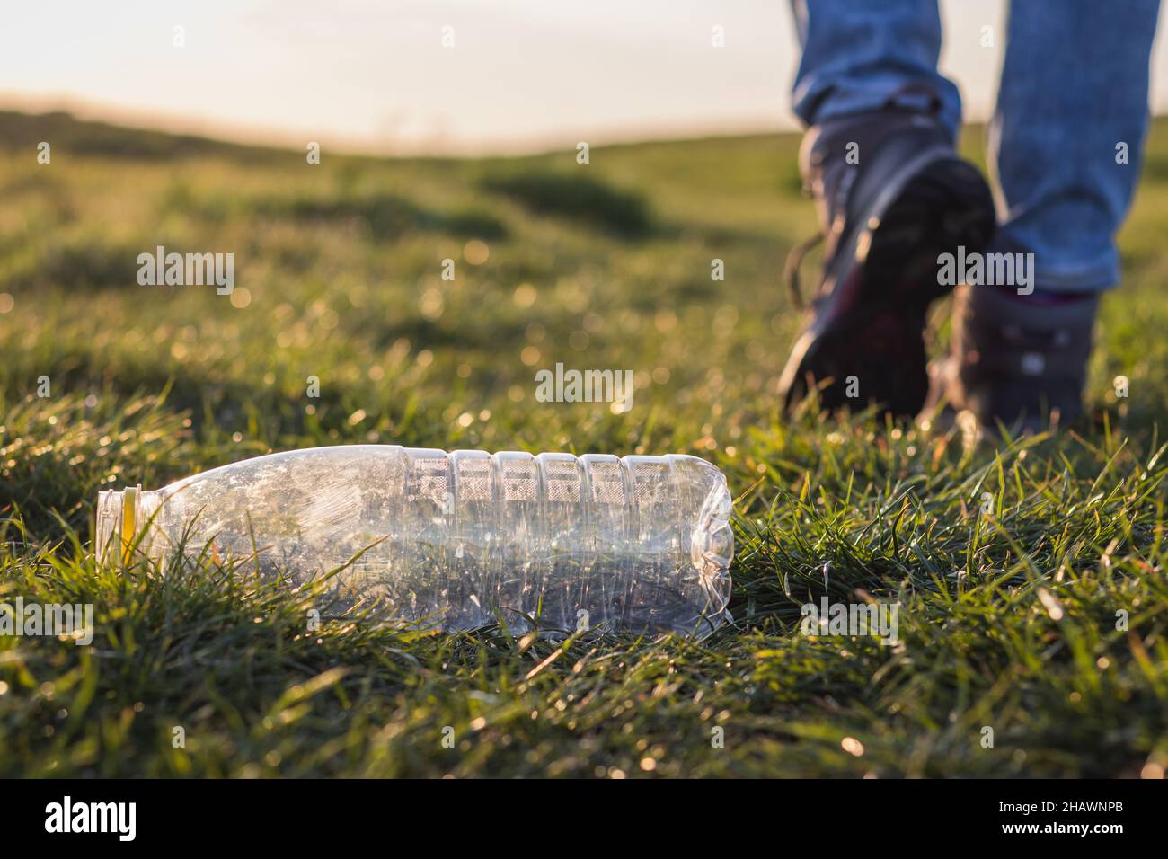 Turista irresponsabile che lascia la bottiglia di plastica all'aperto. Concetto di inquinamento plastico. Danni ambientali in natura Foto Stock