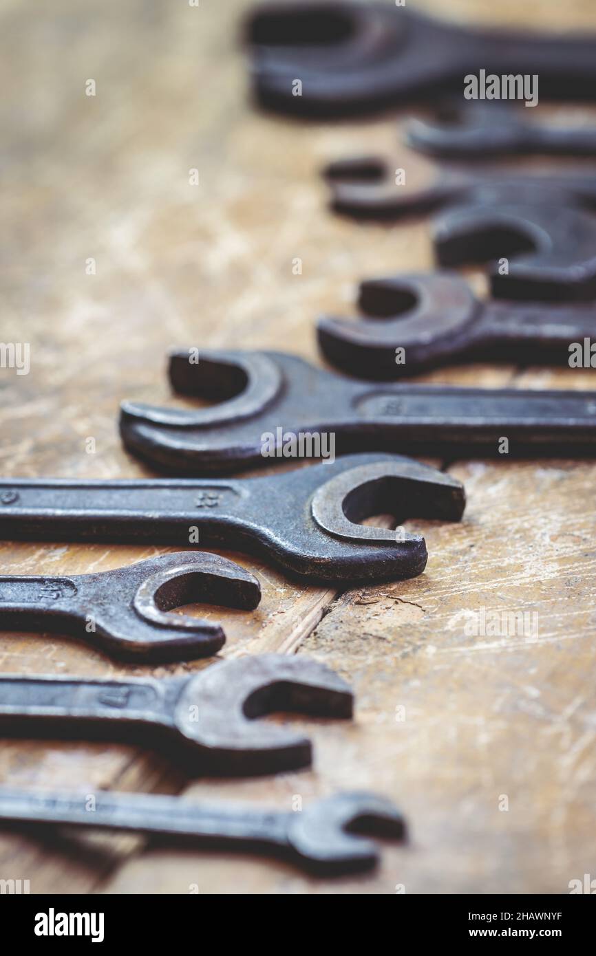 Variazione delle chiavi sul tavolo. Utensile manuale per lavori in metallo. Vecchia chiave d'epoca in officina. Messa a fuoco selettiva Foto Stock