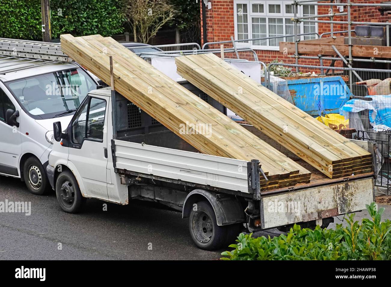 Materiali su costruttori camion pick-up camion fuori casa costruzione cantiere caricato con nuovi travi in legno di conifere &travetti soffitto Inghilterra UK Foto Stock