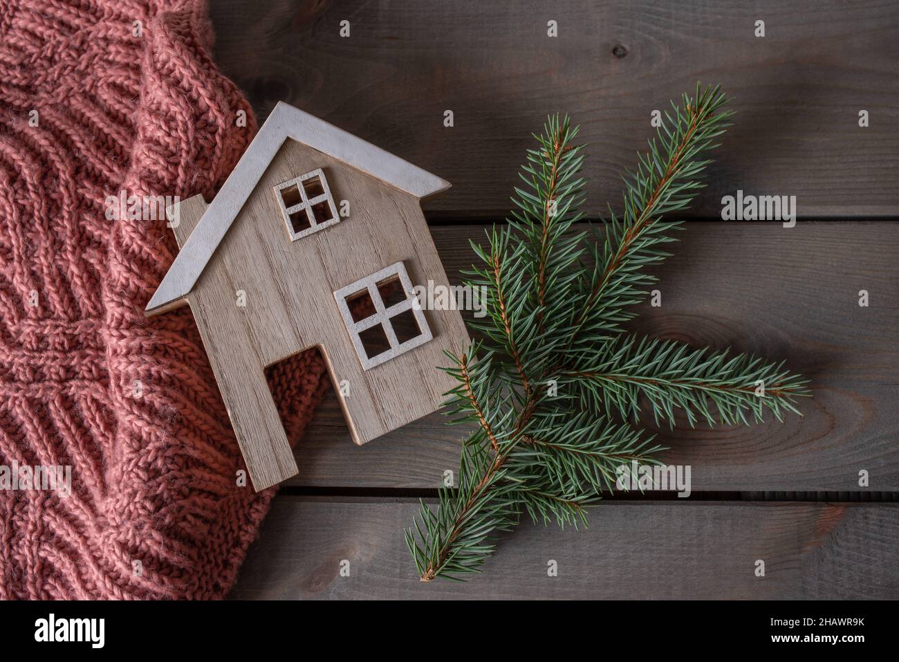 casa giocattolo con sciarpa calda e ramo di pino Foto Stock