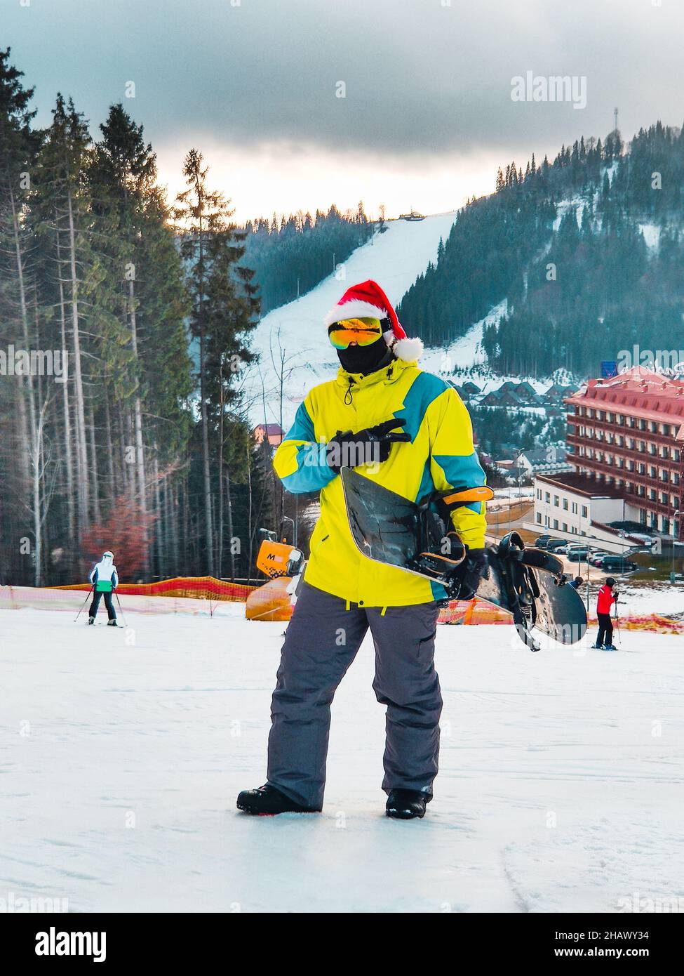 uomo con snowboard in cappello rosso di natale che cammina neve collina  inverno montagna stazione sciistica Foto stock - Alamy