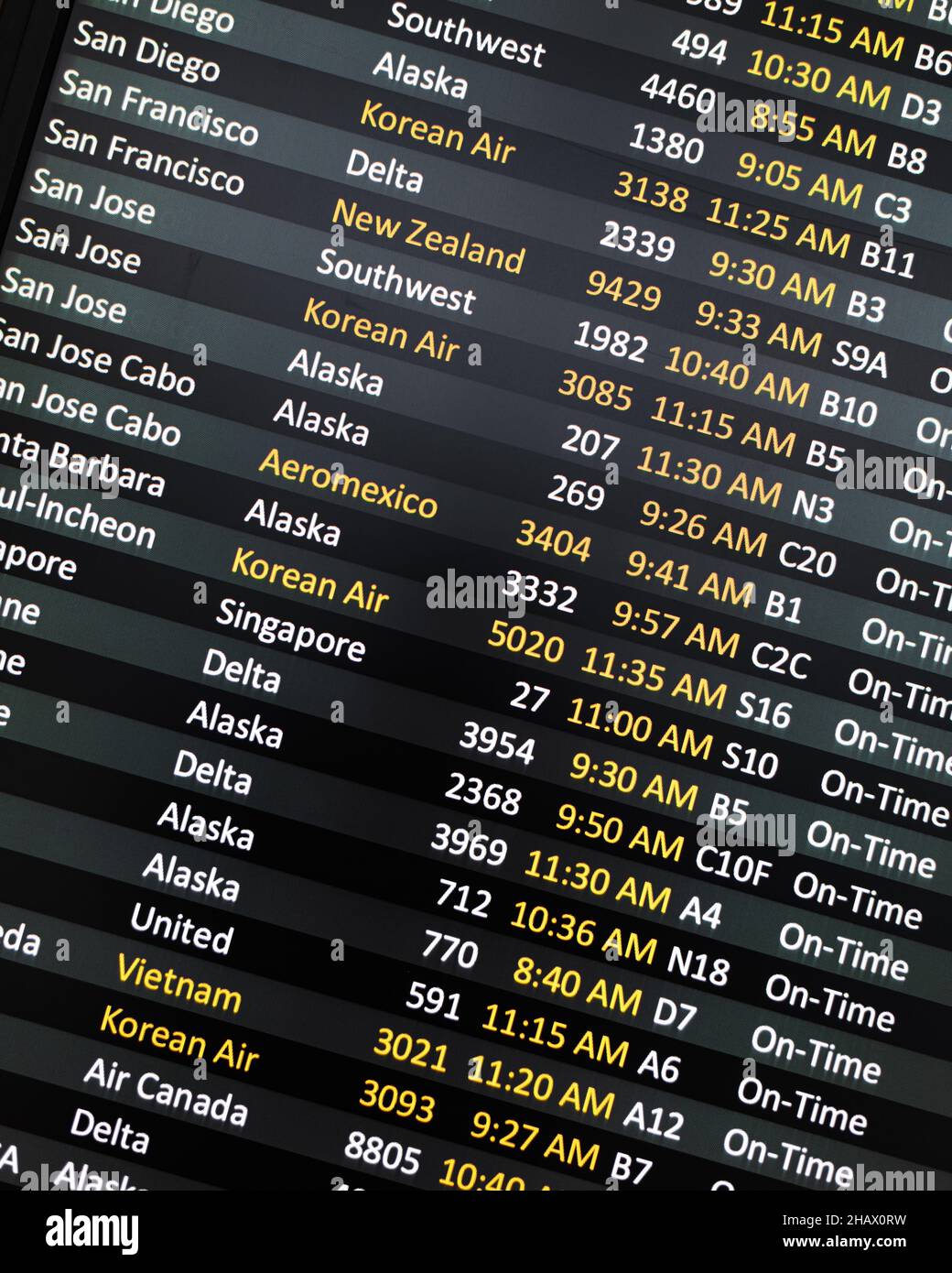 SeaTac, WA, USA - 07 dicembre 2021; Digital Departure Reader Board presso l'aeroporto internazionale di Seattle Tacoma che mostra le città e gli orari delle compagnie aeree Foto Stock
