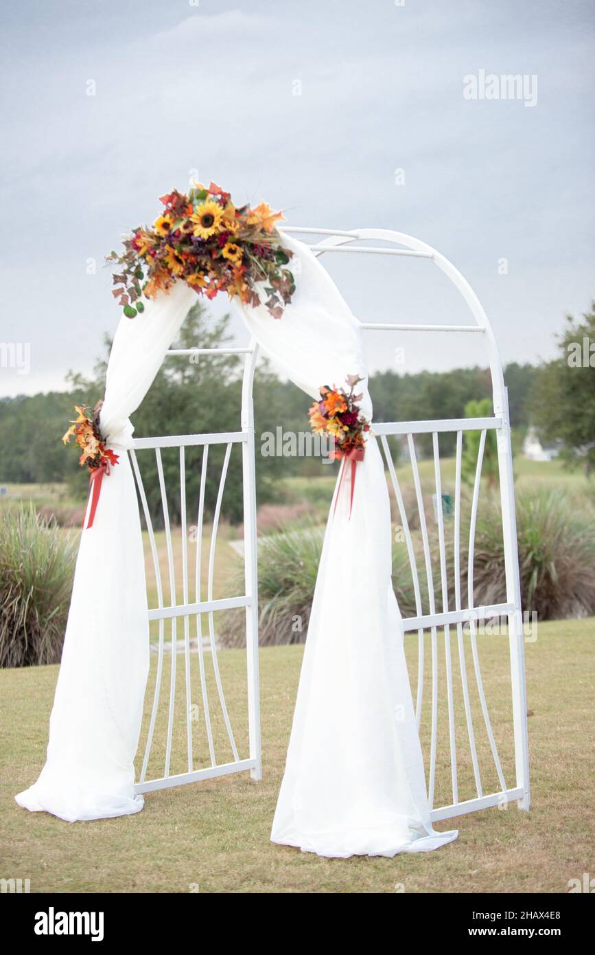 Arco per cerimonia di nozze bianco con frappè in tessuto bianco e decorazioni con girasoli Foto Stock