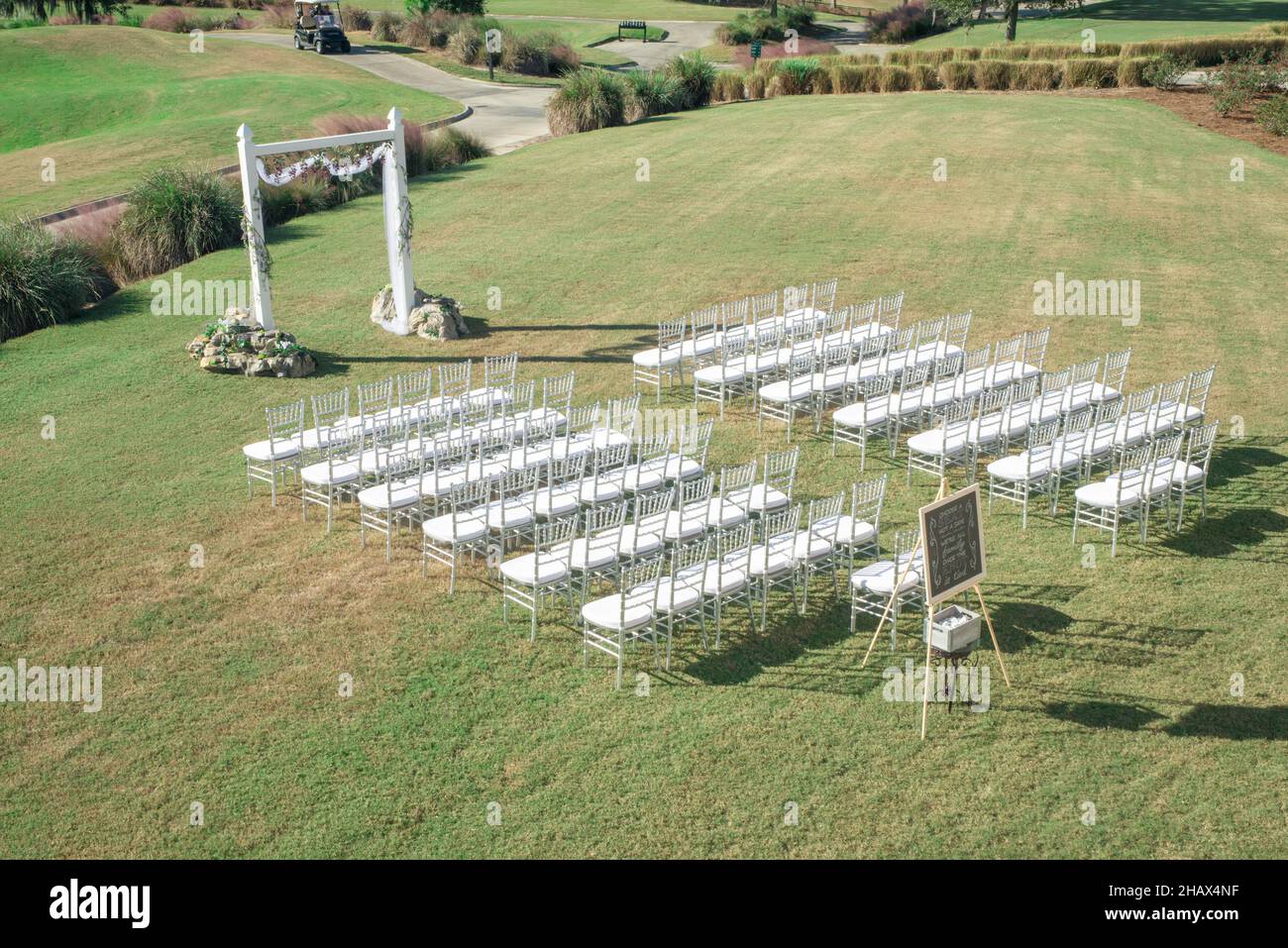Splendida cerimonia nuziale all'aperto con sedie bianche e argentate Foto Stock