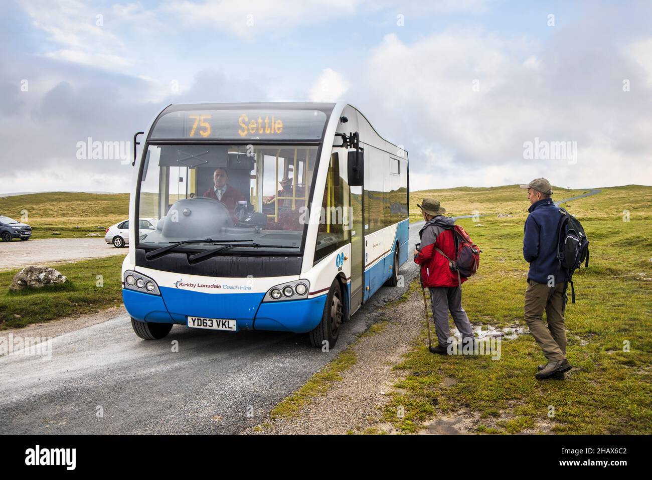 Camminatori che catturano l'autobus della comunità verso Settle da Malham Tarn, Yorkshire Dales, Regno Unito Foto Stock