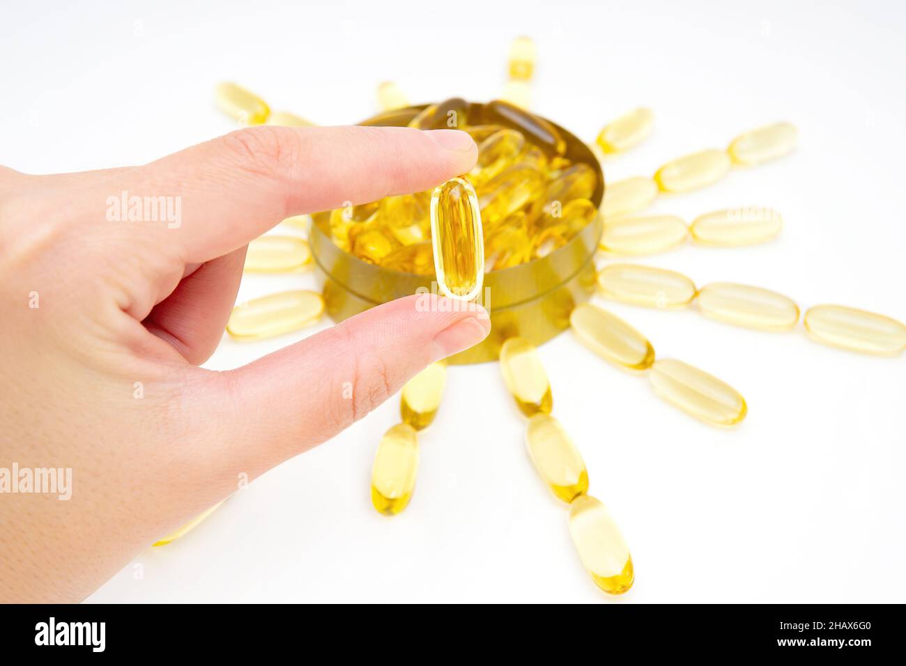 Capsula di olio di pesce in mano. Omega-3 softgel di acidi grassi come buona fonte di vitamina D. Foto Stock