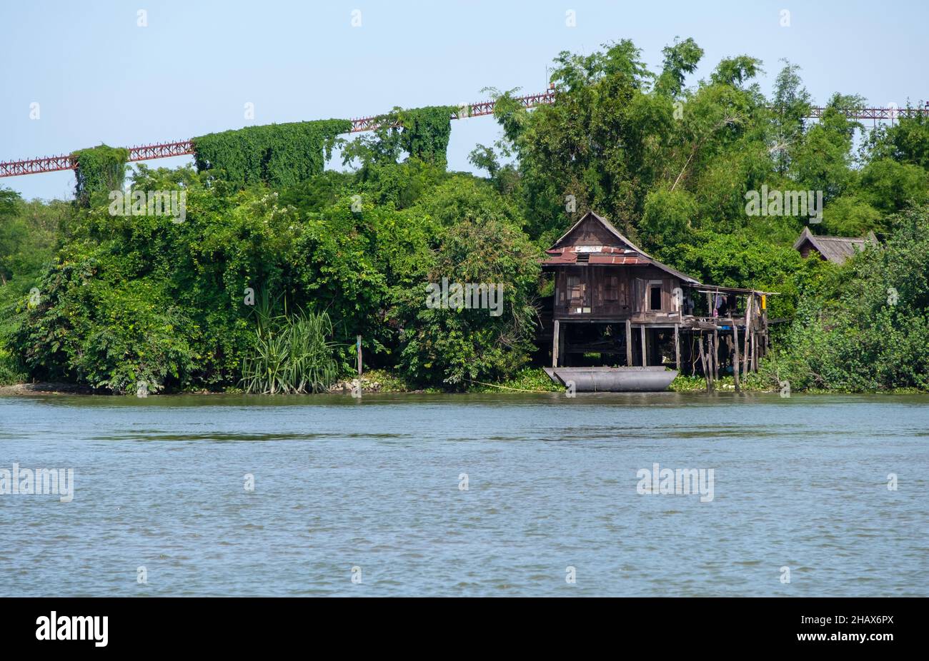 La vecchia casa di legno vicino al grande fiume di fronte al porto di sabbia deserta, vista frontale con lo spazio copia. Foto Stock