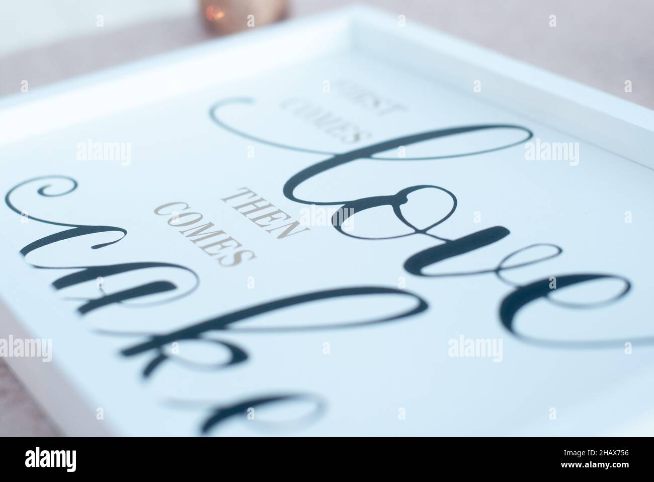 'prima viene l'amore poi viene cake'segno bianco con lettere nere primo piano Foto Stock