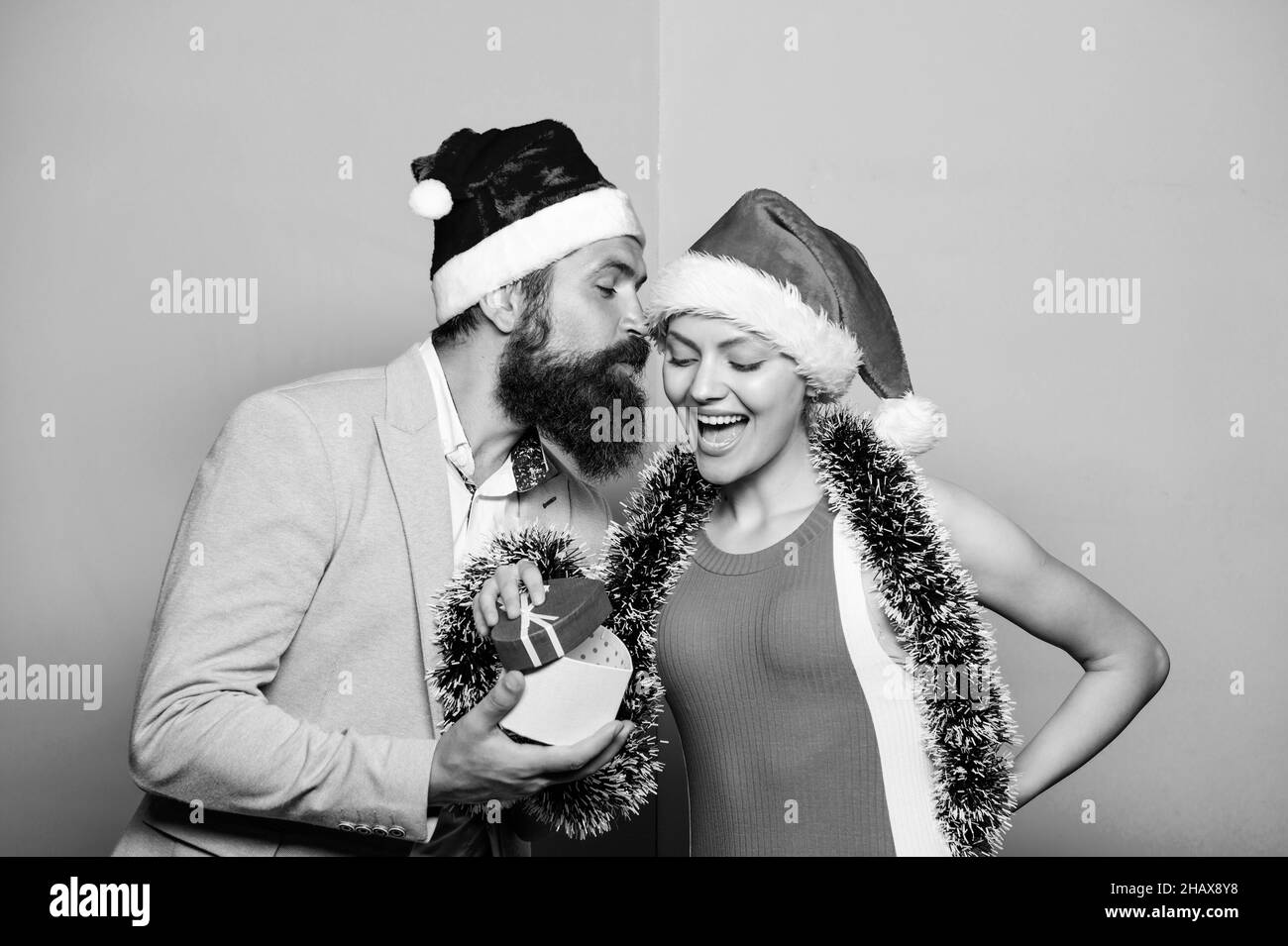 Natale è in arrivo. Felice festa del nuovo anno. Regalo con amore. Tempo per i regali. Felice coppia di famiglia festeggia Natale. santa uomo e donna con tinsel Foto Stock