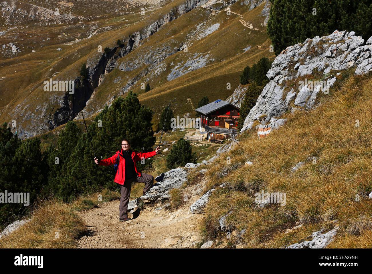 Trekking, Wandern Dolomiten, schöne Frau wandert auf Berge und Felsen am Langkofel, Sasso lungo mit Blick und Aussicht auf eine Berghütte a Südtirol Foto Stock