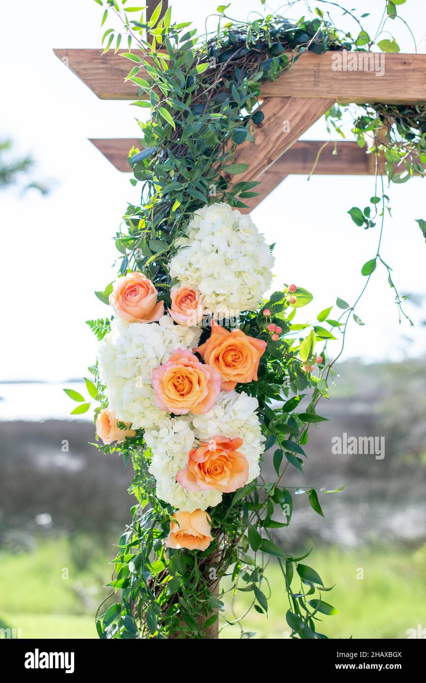 Rose arancioni e fiori di peonia bianca decorazioni su legno cerimonia di nozze arco Foto Stock