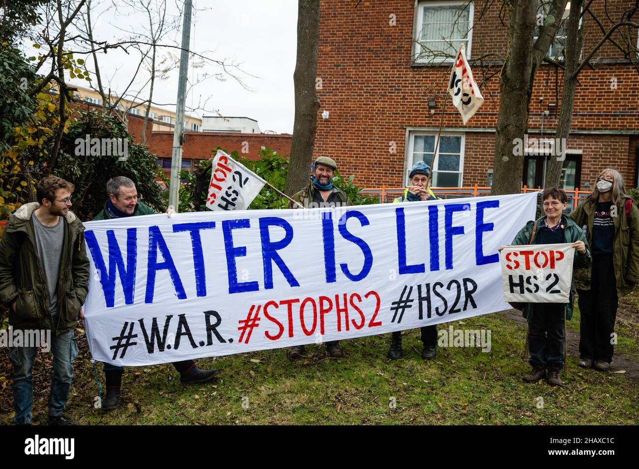 Londra, Regno Unito. 15th dicembre 2021. Stop HS2 gli attivisti posano con un banner fuori dalla Corte dei Magistrati di Uxbridge. L'ex paralimpiano cieco James Brown e il collega attivista 'Jimmy' apparivano in tribunale accusati di danni criminali dopo aver presumibilmente arrampicato su un carro di perforazione da utilizzare per il progetto ferroviario ad alta velocità del HS2 nel febbraio 2020 al fine di sensibilizzare l'opinione pubblica sui rischi derivanti dal lavoro infrastrutturale per l'approvvigionamento idrico di Londra Dal gesso aquifer sotto la valle del Colne. Il caso è stato rinnegato fino al febbraio 2022. Credit: Mark Kerrison/Alamy Live News Foto Stock