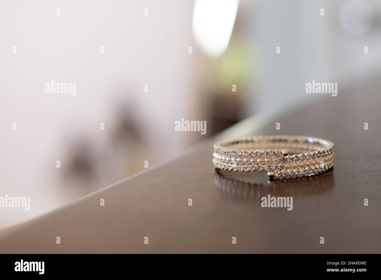 Anello donna con perline d'oro su tavola in legno Foto Stock