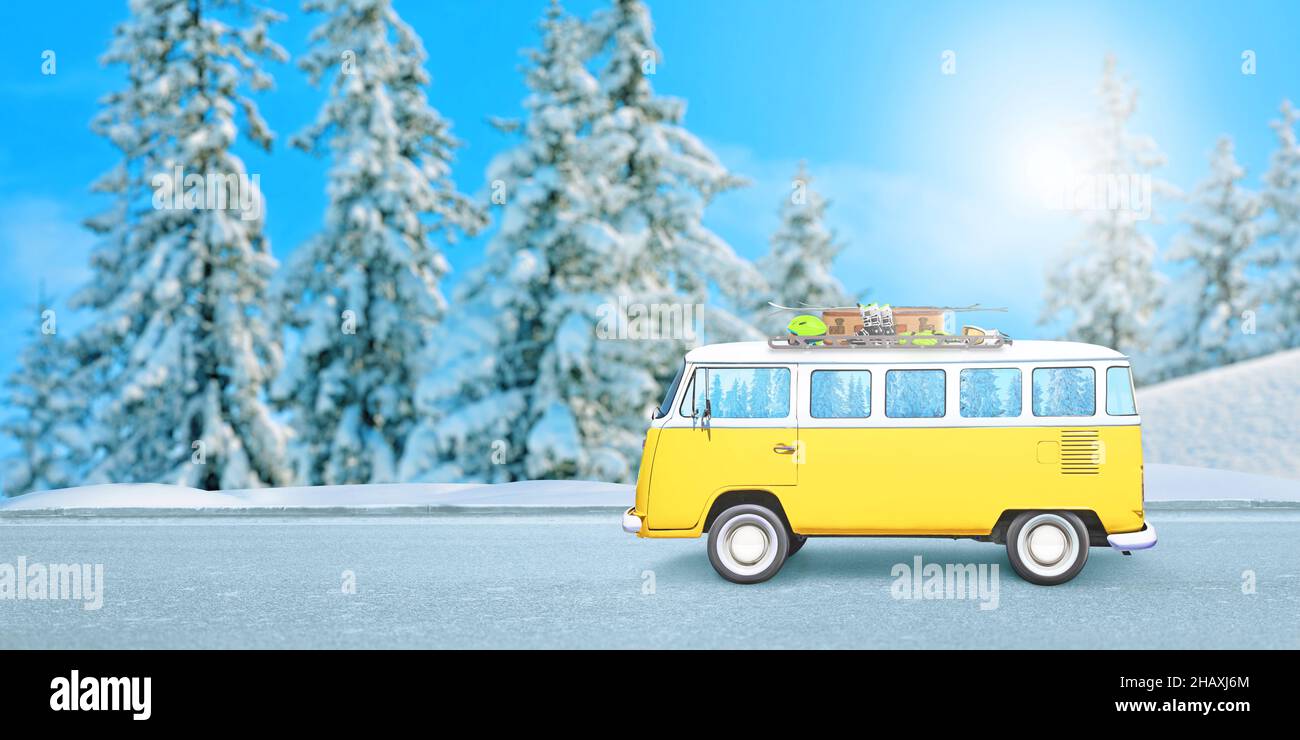 Furgone giallo sulla strada, con attrezzatura da sci sul tetto. Il concetto di viaggiare in una vacanza invernale Foto Stock